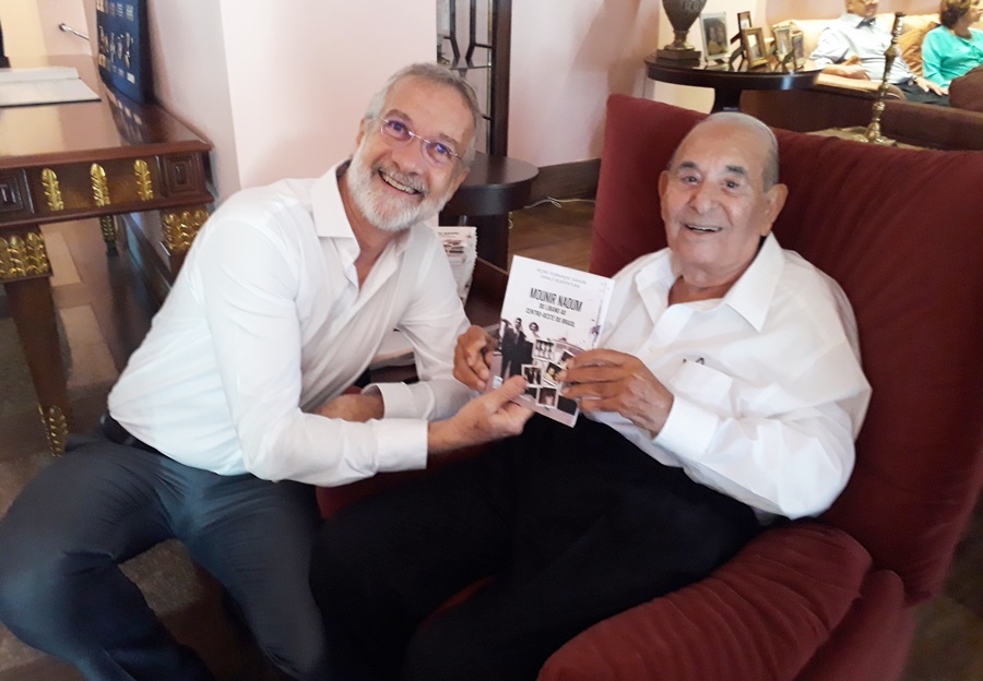 #PraTodoMUndoVer: A imagem mostra o ex-prefeito de Anápolis Pedro Sahium e o empresário Mounir Naoum, segurando um livro com a história dele